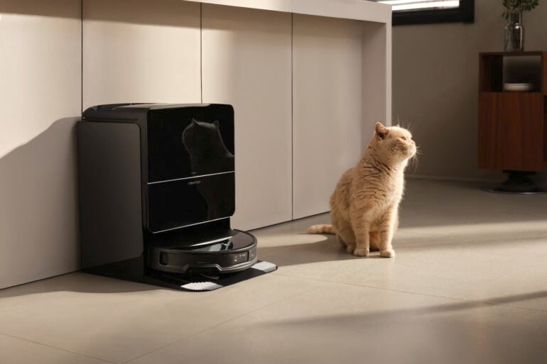 Roborock Saros 10R robot vacuum near orange cat
