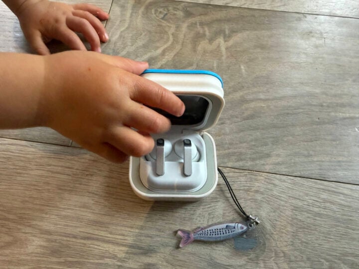 A toddler's hand grabbing at the Galaxy Buds sardine case