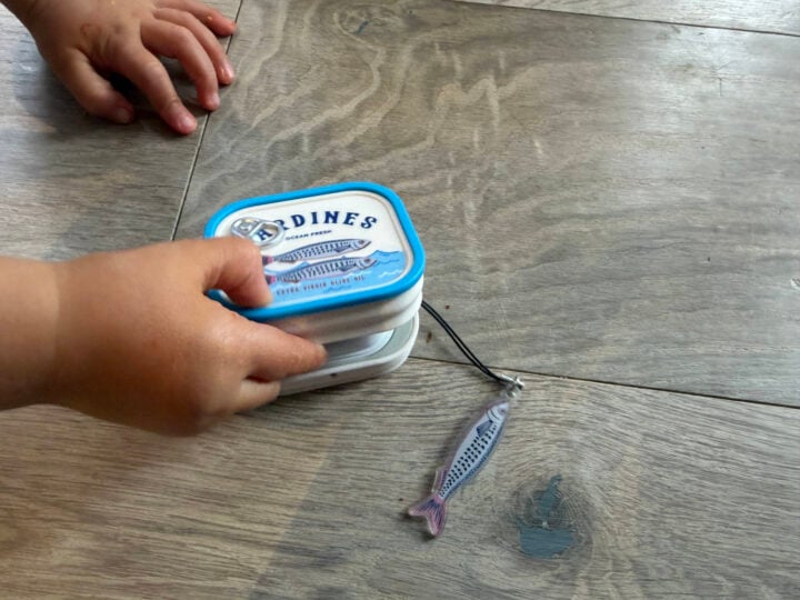A toddler's hand grabbing at the Galaxy Buds sardine case