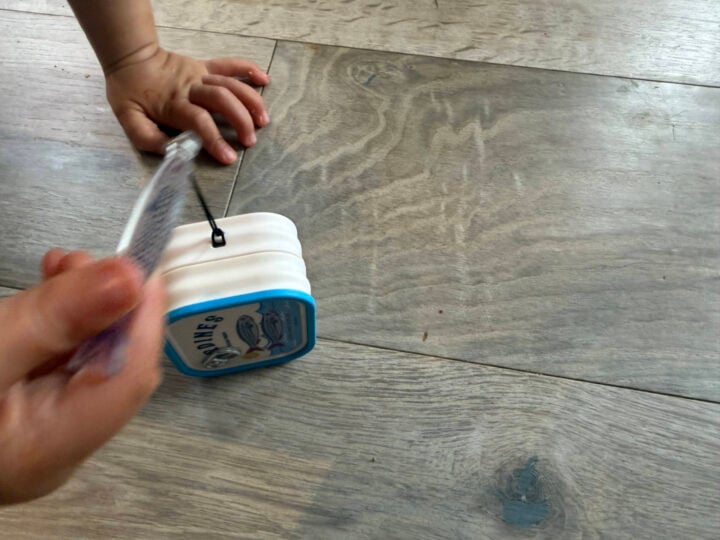 A toddler's hand grabbing at the Galaxy Buds sardine case