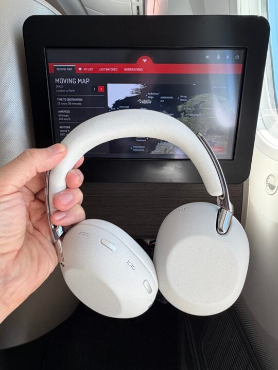Sony 1000X held in front of in-flight map on plane.