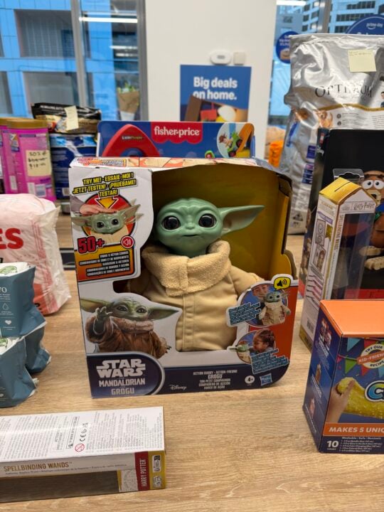 Boxed animatronic Grogu toy from Star Wars The Mandalorian on a table of toys