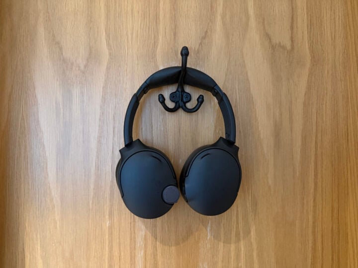 Black Skullcandy Crusher 1080 ANC headphones hanging on hook