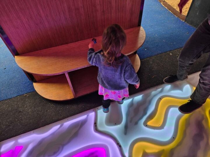 Photo of a young child standing on a colourful floor