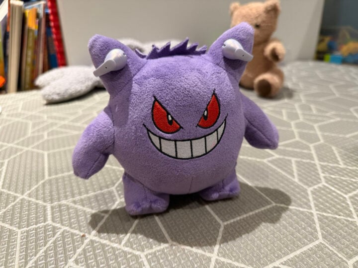 Plush Gengar wearing Shokz OpenDots Air