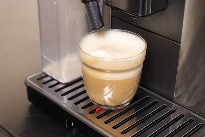 Flat white being poured by  De'Longhi PrimaDonna
