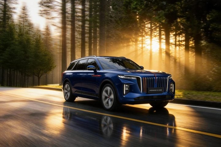 Blue HongQi E-HS9 electric SUV driving on a wet forest road at sunrise