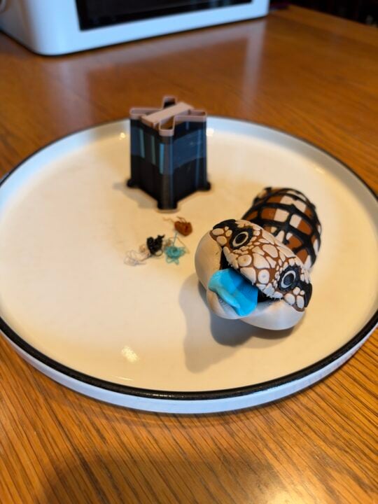 Small pile of filament scraps next to a 3D printed blue-tongue lizard printed on the Snapmaker U1